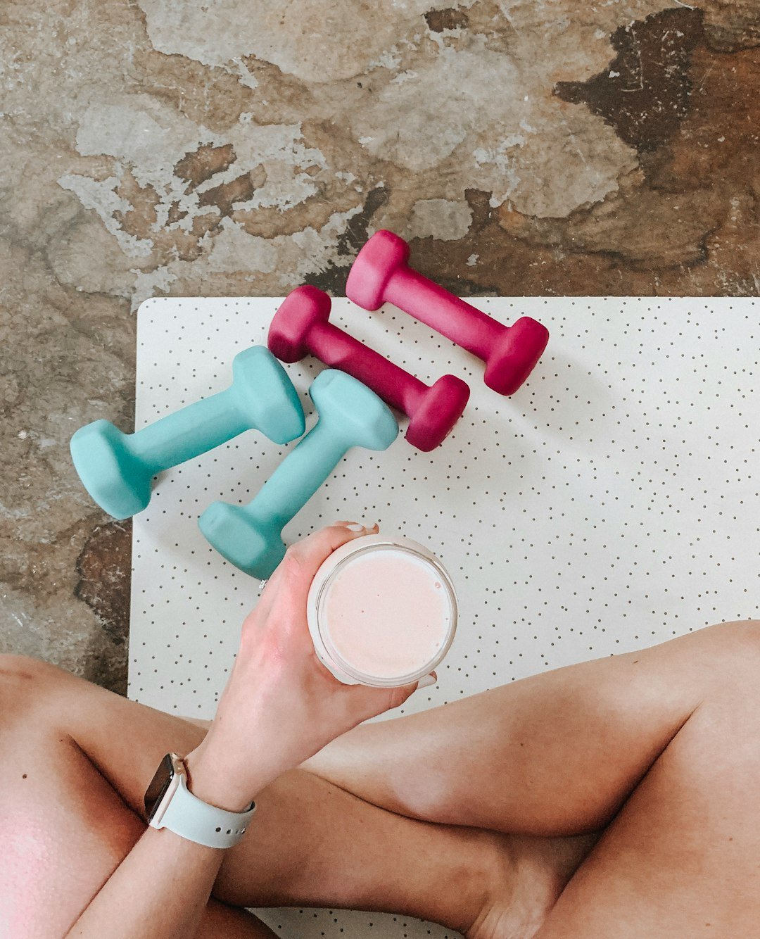 about-03 person-holding-white-liquid-filled-cup-above-two-pairs-of-dumbbells-qqvti5edc
